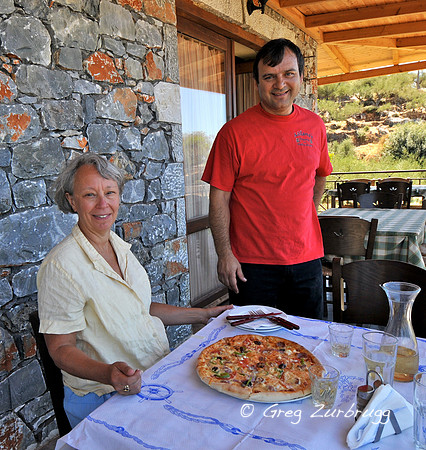 Being served our favorite Greek pizza by the proprietor of an Exochori Taverna.