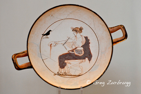 Apollo's wine drinking cup. The god has his turtleshell lyre and is pouring an offering to himself.
